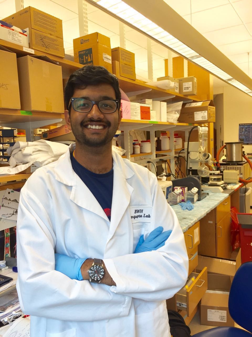 Somesh Mohapatra in a lab coat and gloves in a research lab